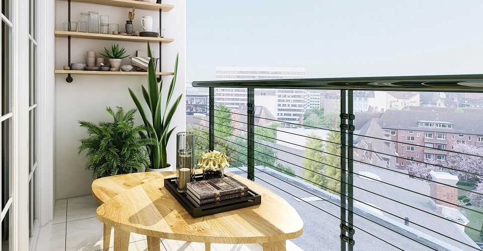 Balcony with metal railing and wooden table and flower pots