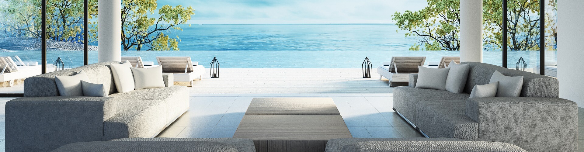 Sofas with cushions and a table in front of the sea